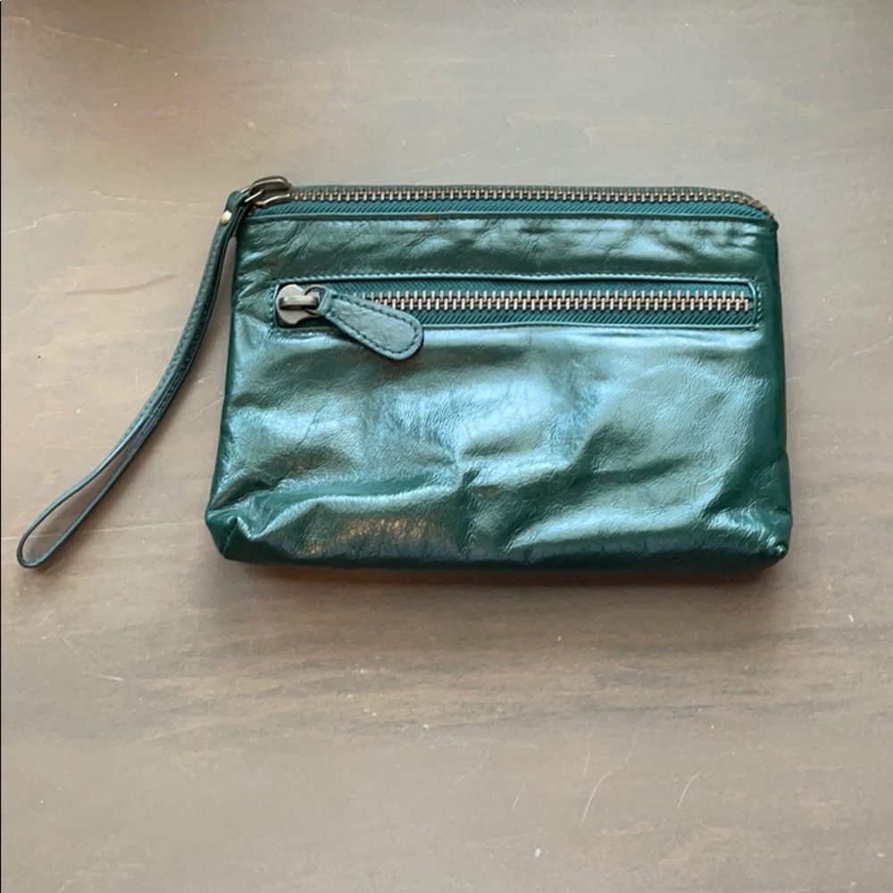 Latico wristlet in hunter green. Front zipper pocket w/wrist strap.